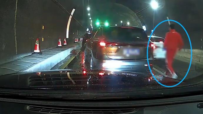 隧道堵车，路过司机下车小跑为救护车开道