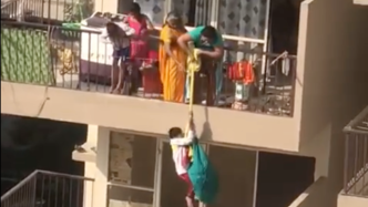 为捡回掉落衣物，印度一母亲将儿子悬吊10楼半空