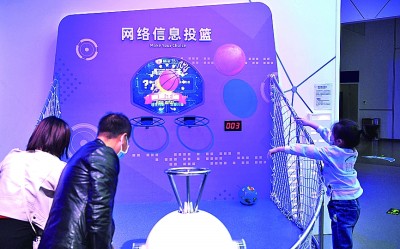 在位于河南郑州高新区的网络安全科技馆内，市民带着孩子体验“网络信息投篮”游戏。新华社发