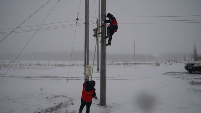 新疆遇风吹雪天气，工作人员巡检保障供电稳定
