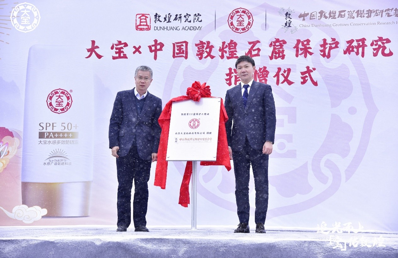 追光而上,“宝”佑敦煌 捐赠仪式现场揭碑 左:敦煌研究院副院长郭青林 右:强生消费品中国区总裁汪轶