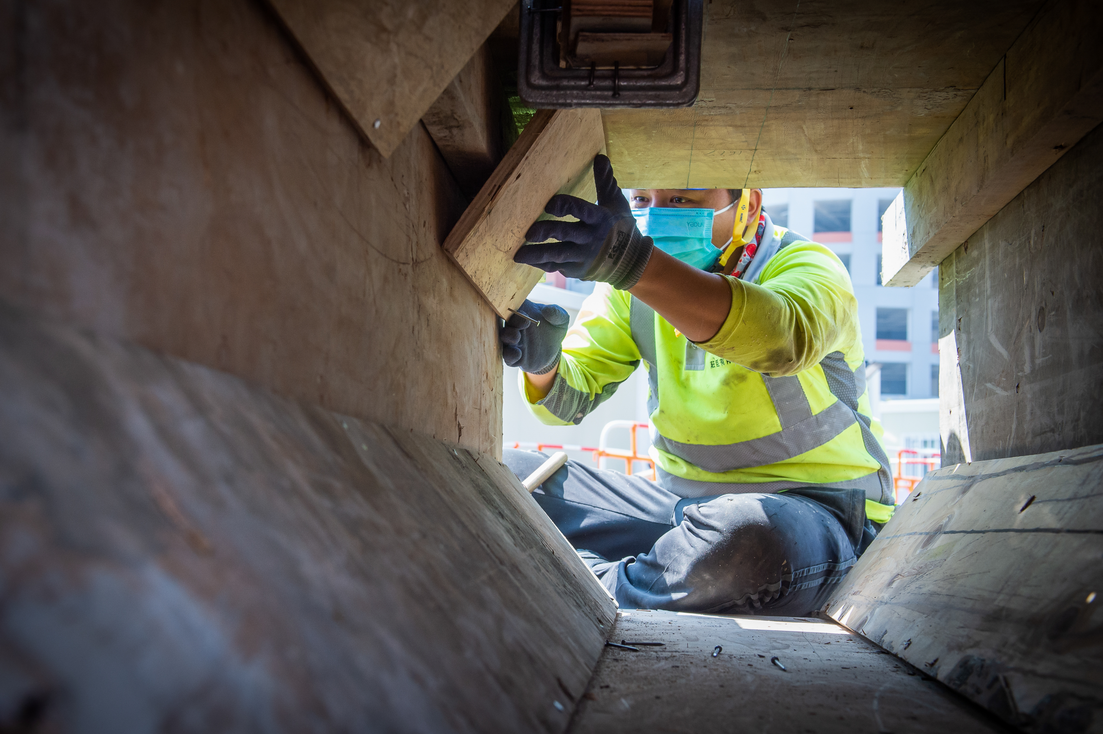 2月26日,香港青衣方舱医院建设工地,工人正在钉板.