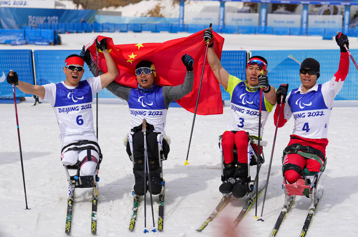 3月9日，冠军中国选手郑鹏（左二）、亚军中国选手毛忠武（右二）和队(dui)友刘子旭（右一）、王涛在北京冬残奥会残奥越野滑雪男子短距离（坐姿）决赛后。新华社记者胡虎虎摄