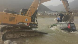 越野车开入河中两人被困，民警带来挖掘机救援