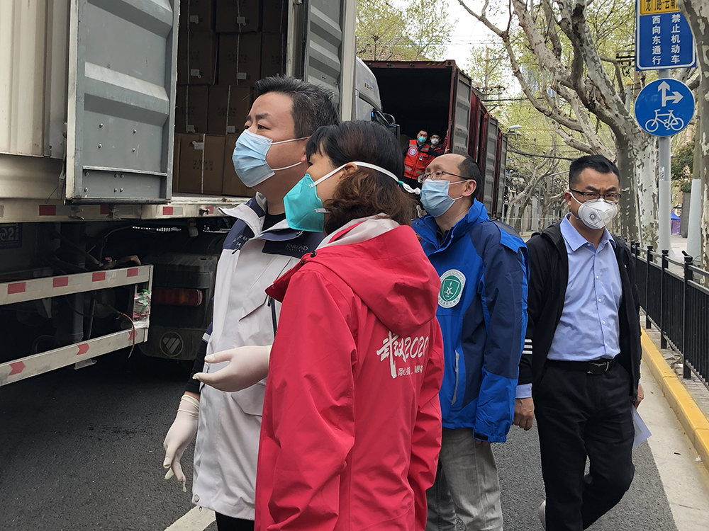 在驻地酒店门口，程芳和湖北支援上海医疗队员们查看物资。