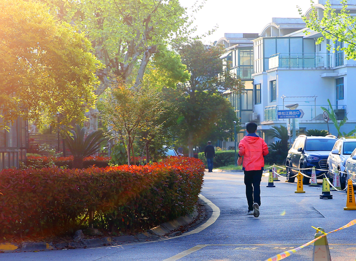 2022年4月12日早晨,上海,划为防范区的松江街道,小区居民在小区内晨跑