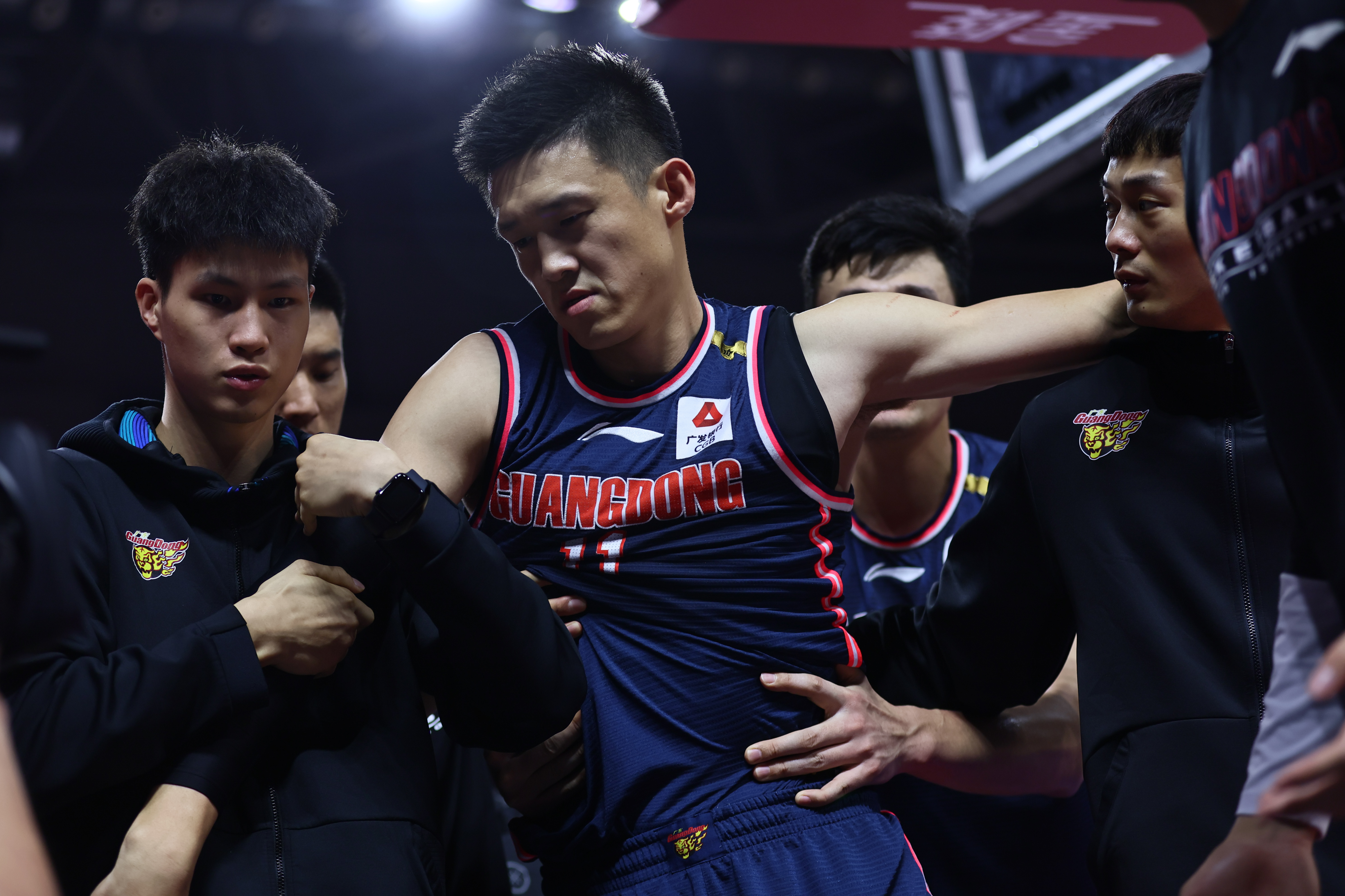 周鹏被队友扶出球场.