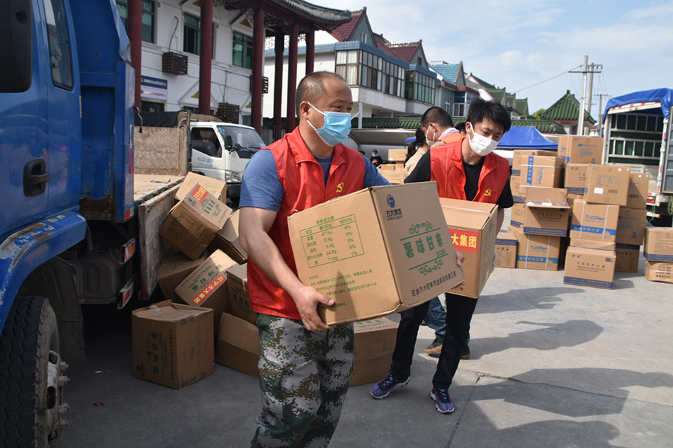 杨圆欢（左一）组建了一支由村干部、党员志愿者、快递小哥等组成的配送队伍。本文图片均由上海金山区提供
