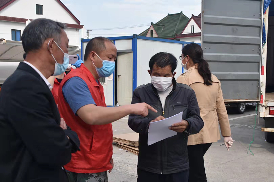 杨圆欢（左二）让村干部每天统计大家的物资需求，统一从超市采购后，再发放到村民手中。