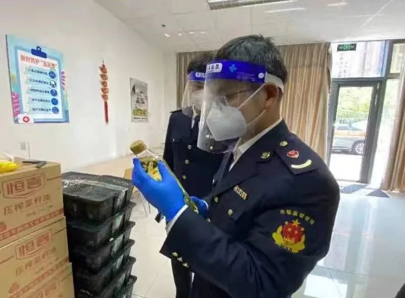 (图为区市场监管局正在对该批次下发的食用油进行核查)