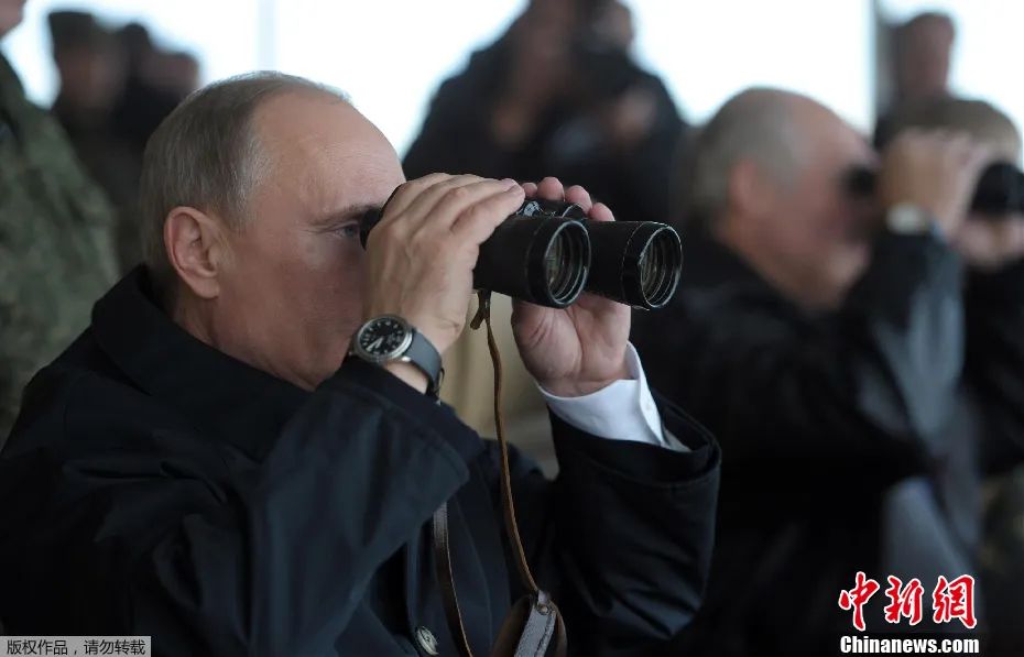 资料图：俄总统普京用望远镜观看军演。