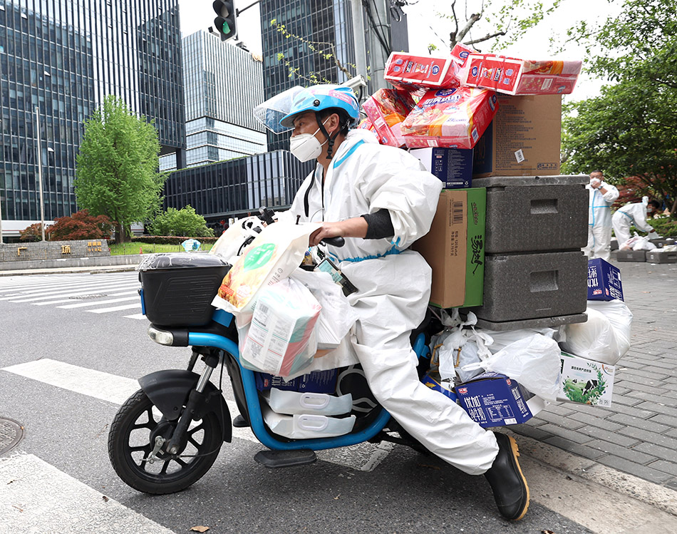 2022年4月15日,上海,江西籍送货员刘增雨驾驶装满货物的电动车开始