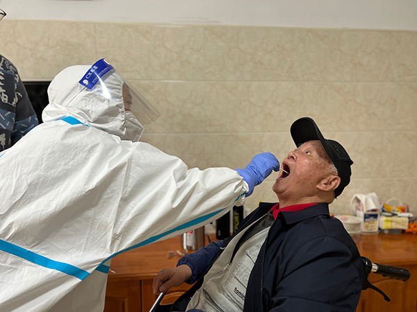 敬老院工作人员为老人进行核酸采样。