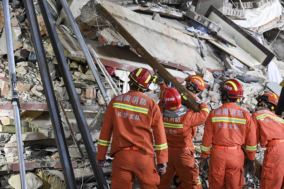 2022年4月29日，长沙市望城区一栋居民自建房倒塌，救援人员用钢管和木头加固邻近的楼栋。 中新社记者 杨华峰 摄