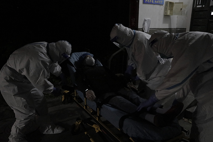 急救医生马天成、司机倪浩良、急救员丁浩俊三人急救小组把病人抬到救护车上。