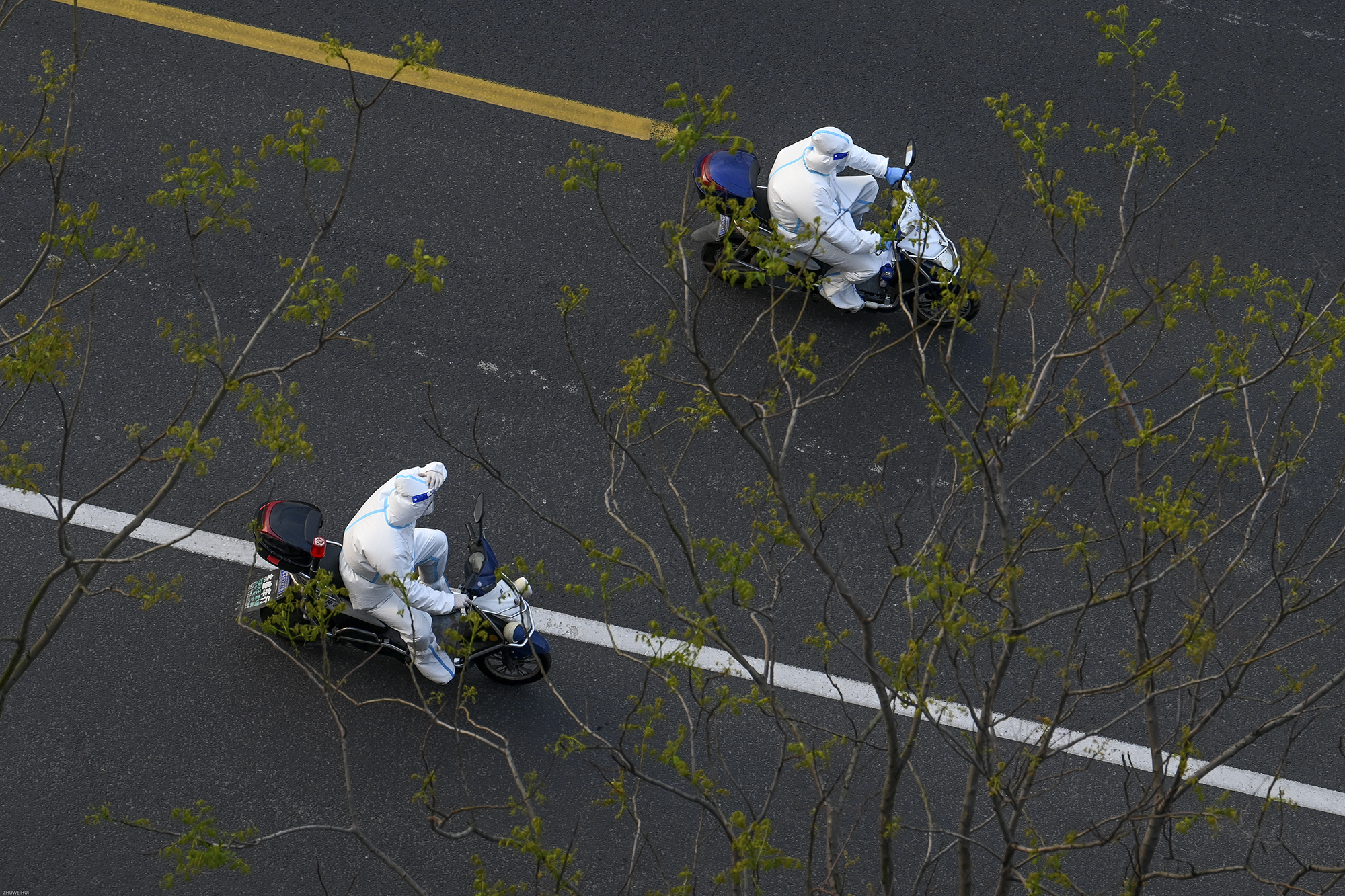2022年4月6日，上海晶华坊，业祥路上，两位大白骑着电瓶车。