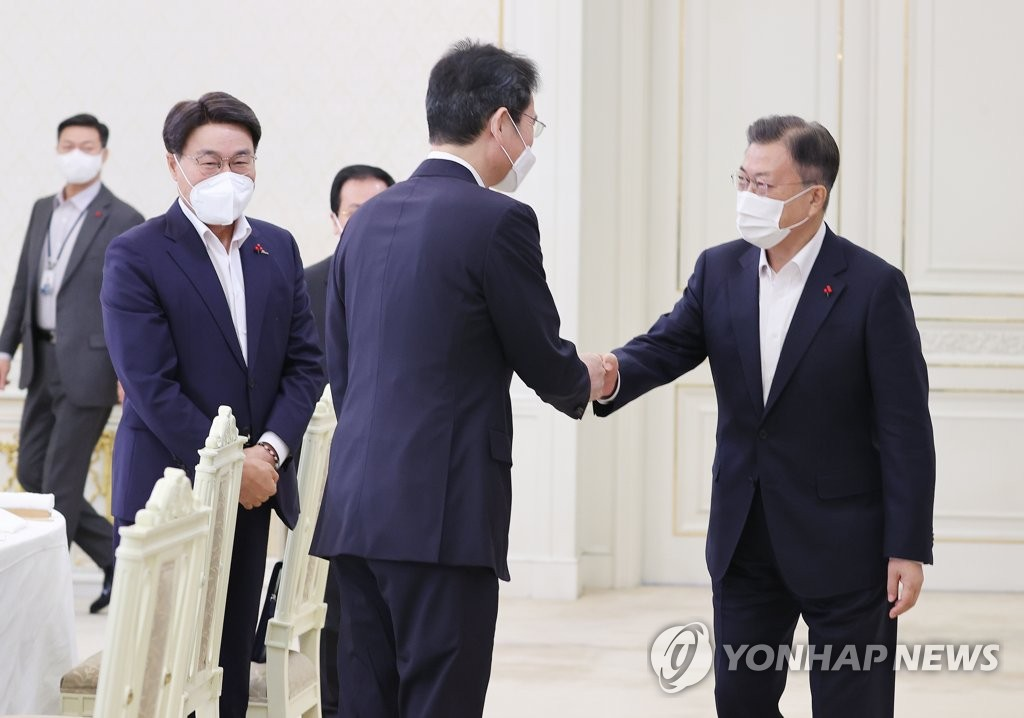 2021年12月27日，在青瓦台，文在寅与李在镕握手。