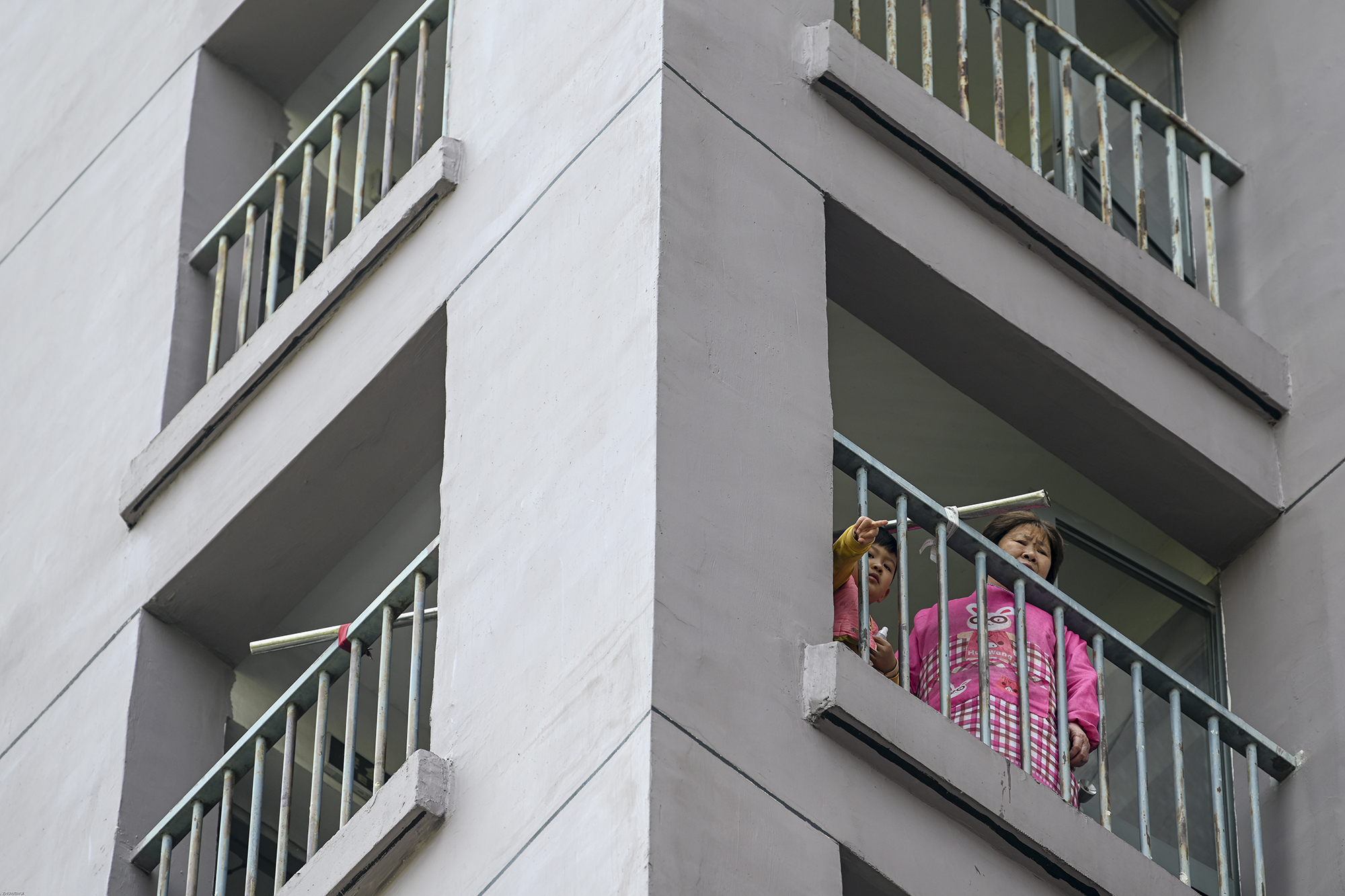 2022年4月21日，上海晶华坊，小男孩和他奶奶在阳台上找楼下做志愿者的爸爸。