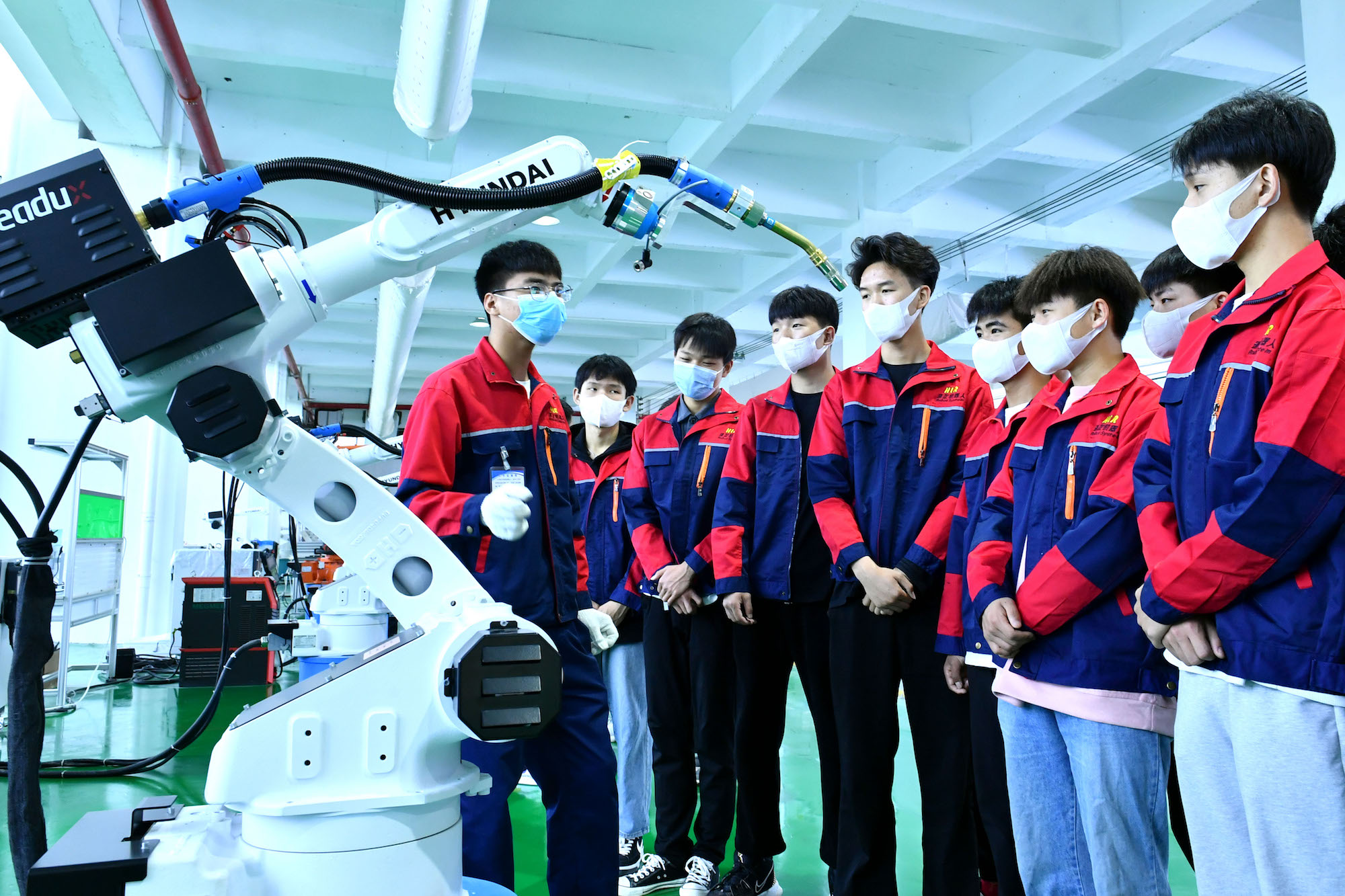 2022年4月28日，河南省商丘市，夏邑县孔祖中专学生在了解机器人工作原理。