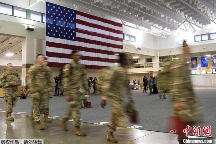 2022年3月11日，部署到欧洲的美军士兵在亨特陆军机场经过一面巨大的美国国旗。