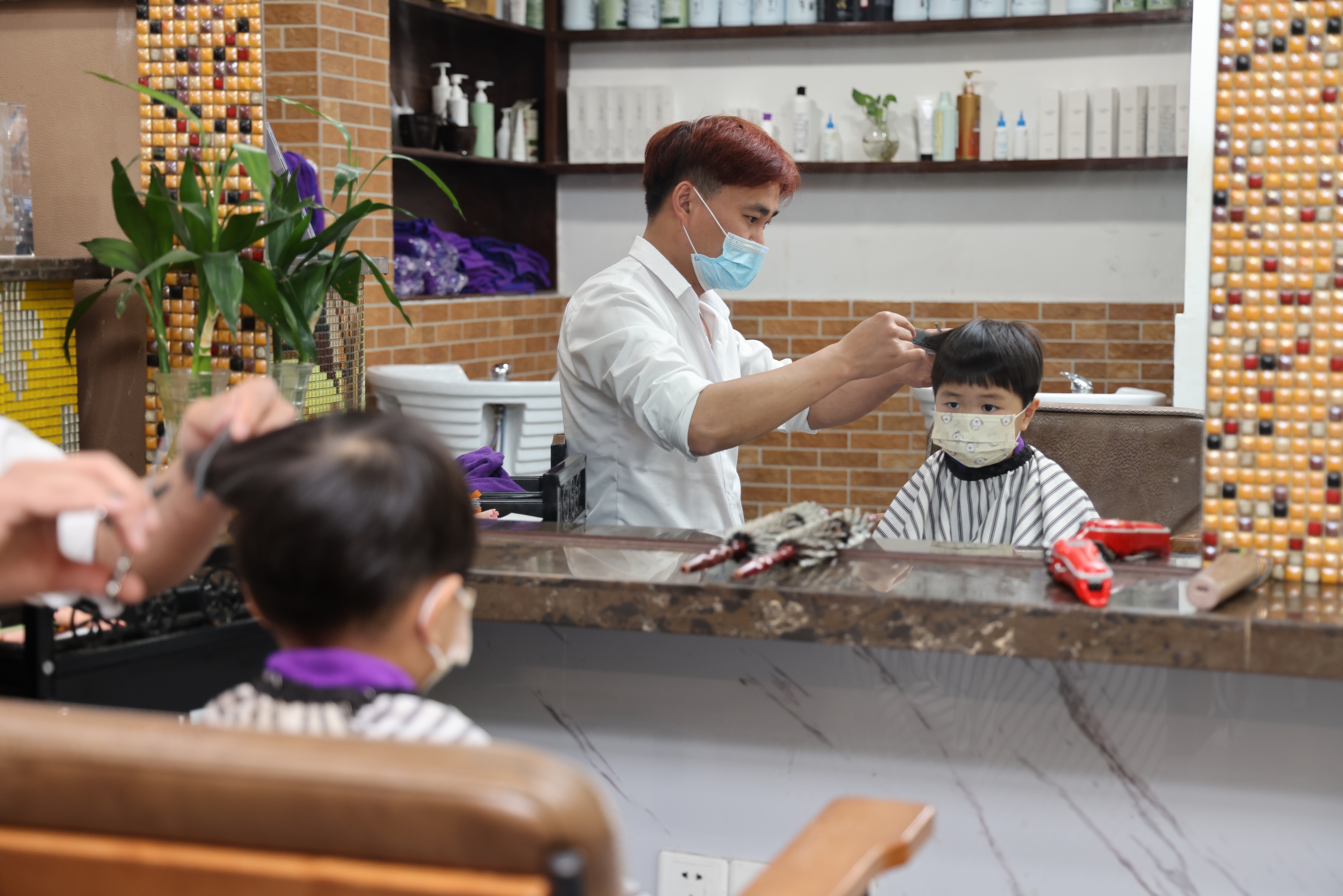 上海金山区朱泾镇的理发店16日恢复营业,小朋友来理发 