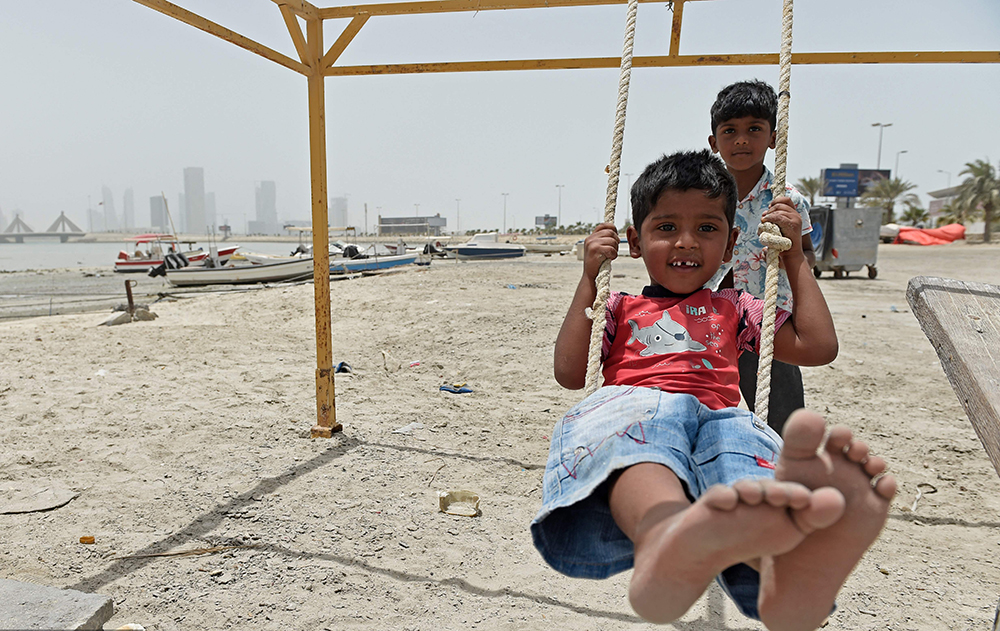 当地时间2022年5月17日，巴林首都麦纳麦，孩子们在沙尘暴中玩耍。