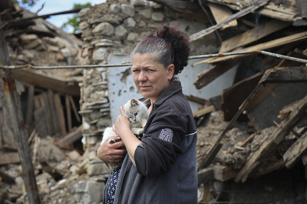 当地时间2022年5月17日，顿涅茨克马里乌波尔，一名乌克兰妇女站在被毁的建筑前。