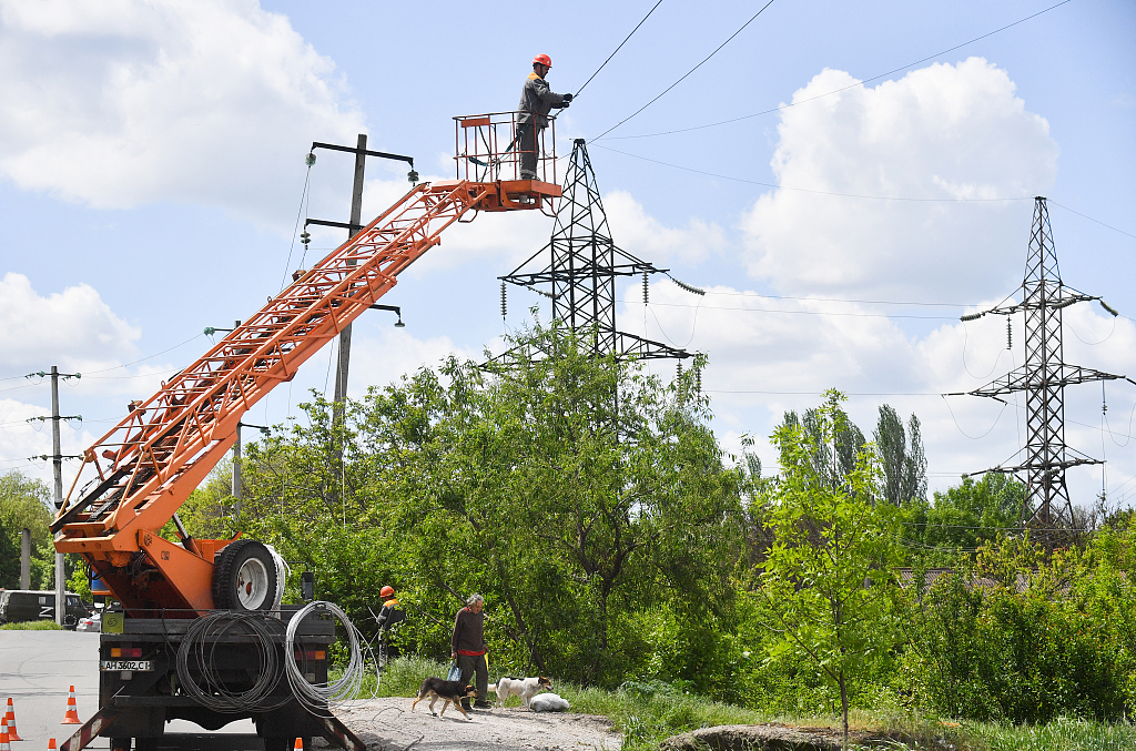 当地时间2022年5月16日，顿涅茨克马里乌波尔，工人拆除被毁的电线杆，重新安装电线。