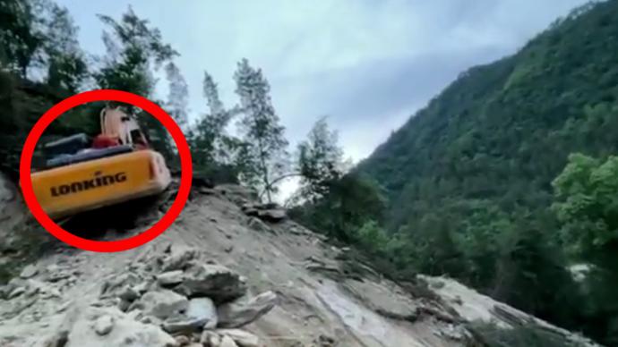 工地巨石滑落将挖掘机砸到悬崖边，消防救出驾驶员