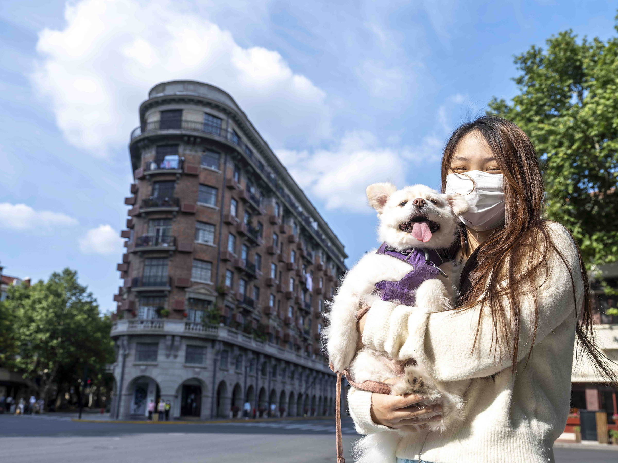 2022年5月21日，武康大楼前，抱着狗拍照的女孩。本文图片均为澎湃新闻记者 许海峰 拍摄