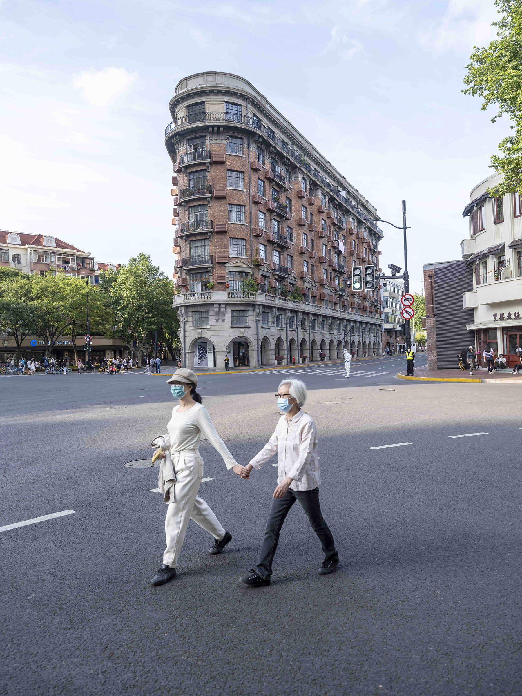 2022年5月21日，两人牵着手走过武康大楼前。