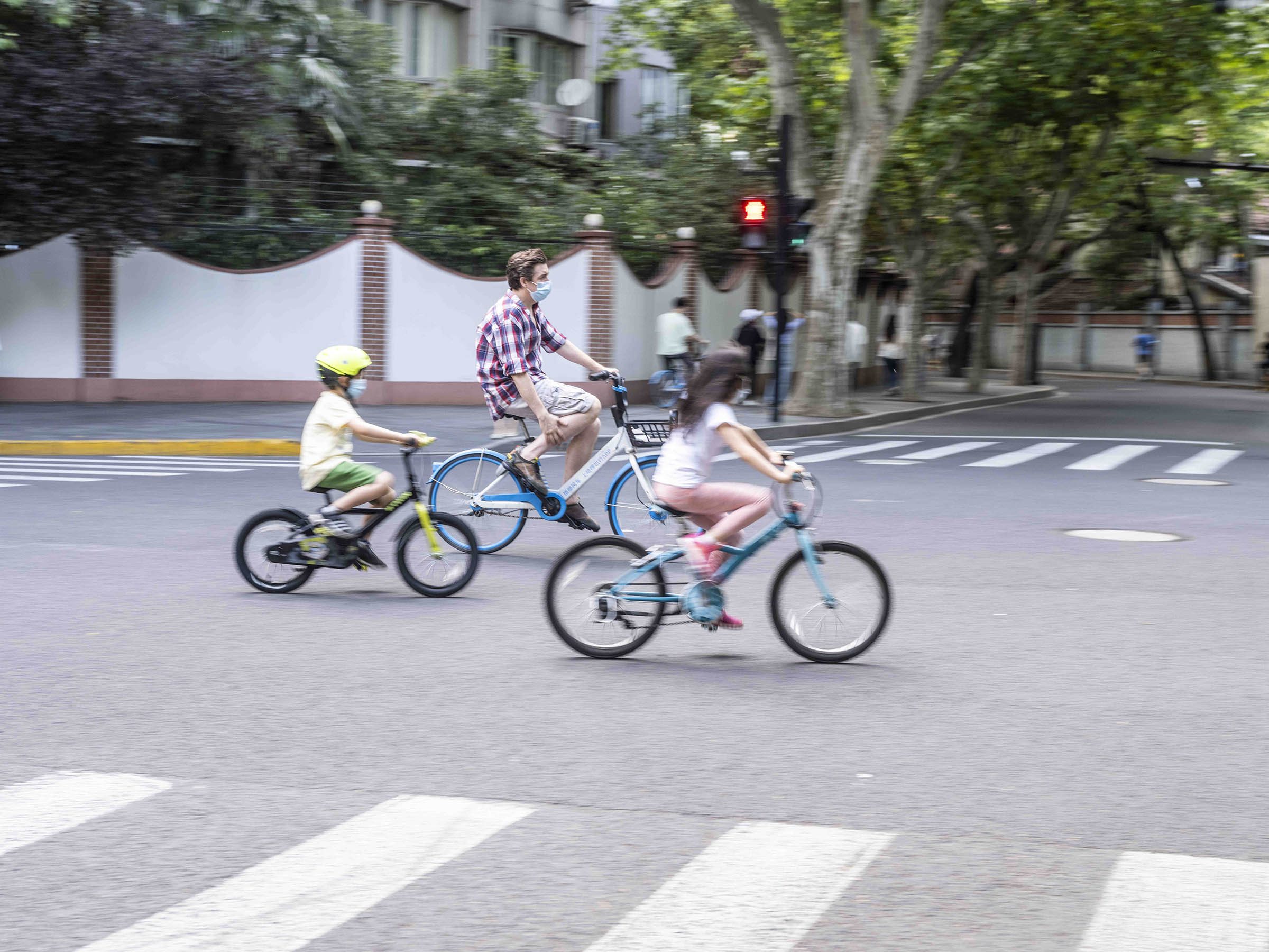 2022年5月21日，武康路复兴西路路口，三名外籍人士骑车而过。