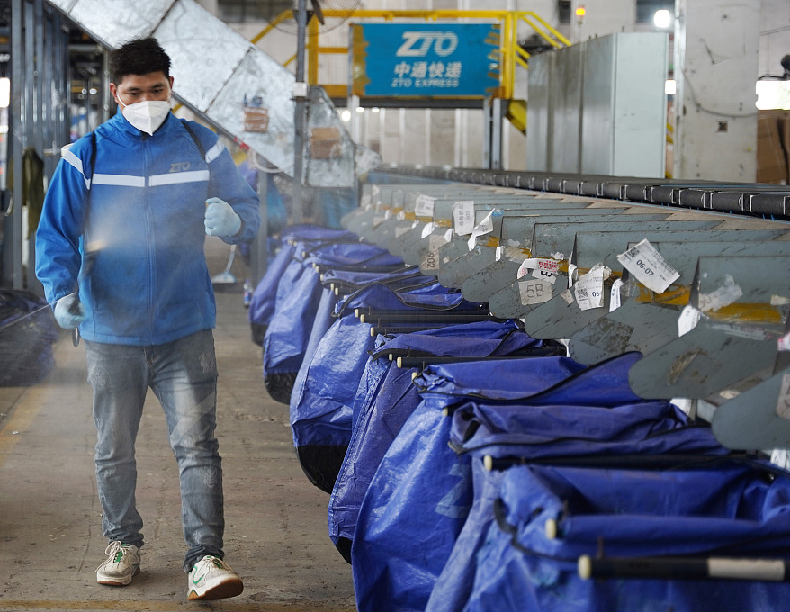 2022年4月29日，上海，中通快递工作人员正在对快递包裹进行消杀。