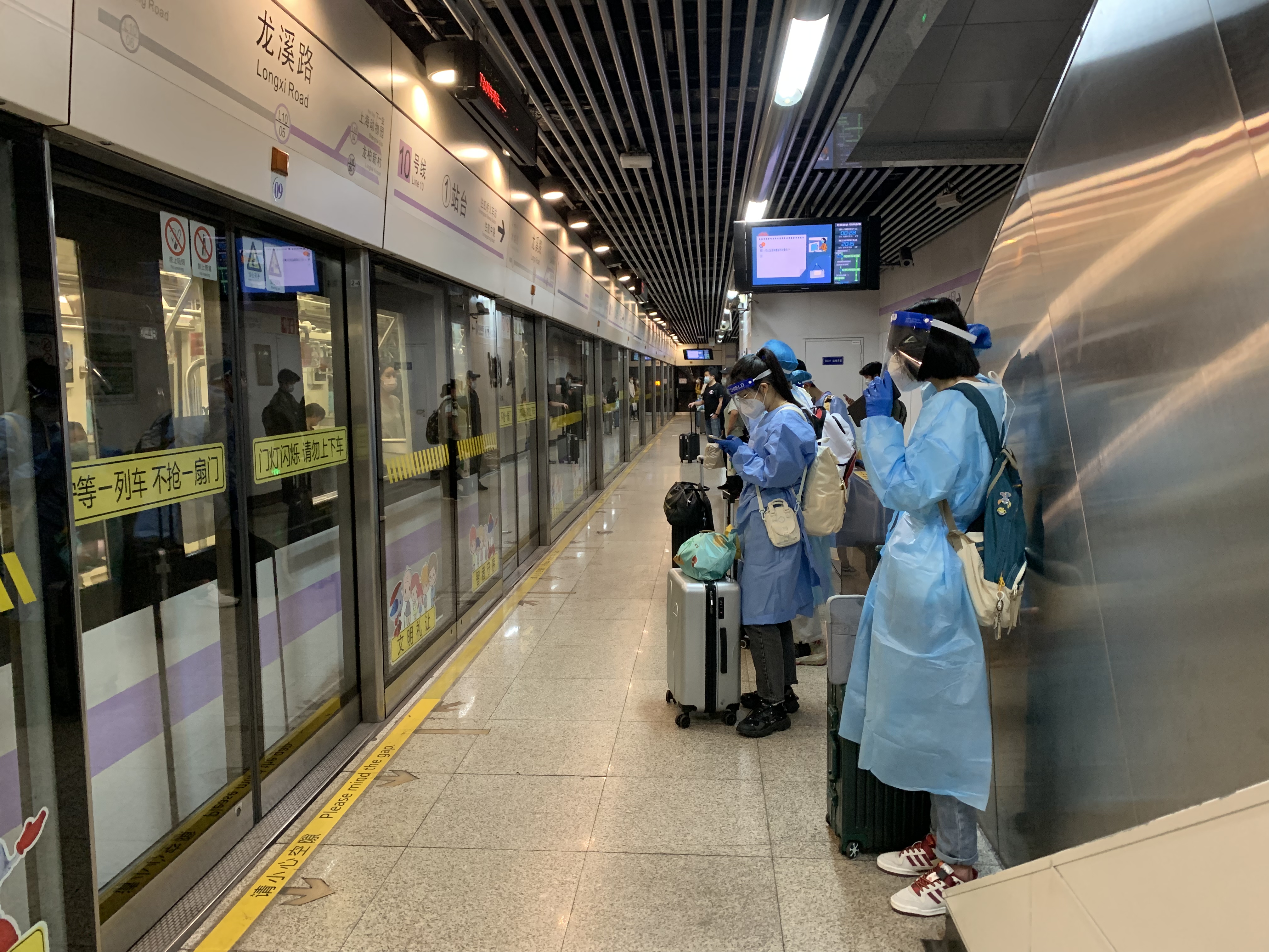 上海出行记地铁10号线站拉开铁栅栏乘客大多带着行李箱