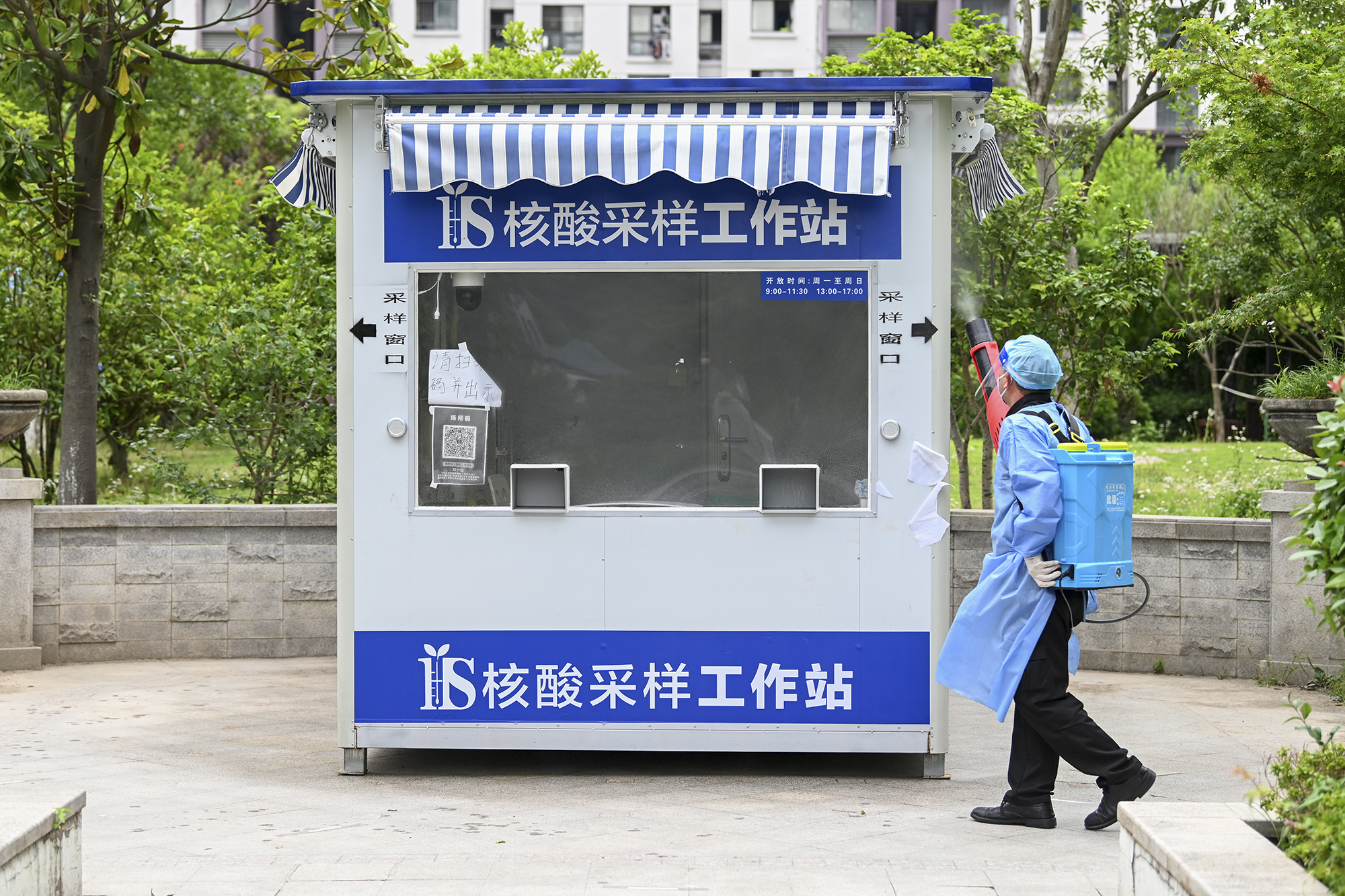 2022年5月19日，上海晶华坊，小区安装了一个核酸采样工作站，保洁人员正在做消杀。