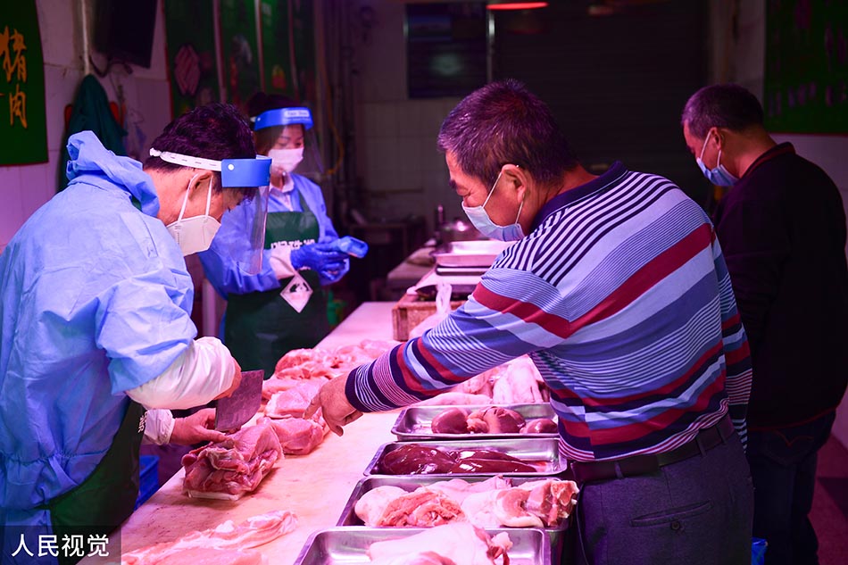 2022年5月17日，上海崇明，居民在庙镇集贸市场购买蔬菜。 