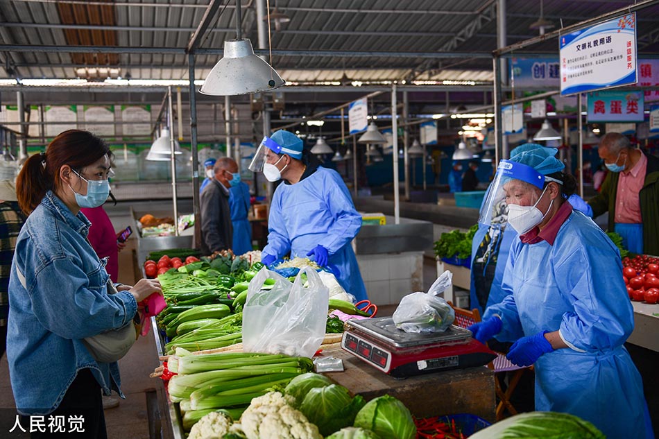 2022年5月17日，上海崇明，居民在庙镇集贸市场购买蔬菜。 