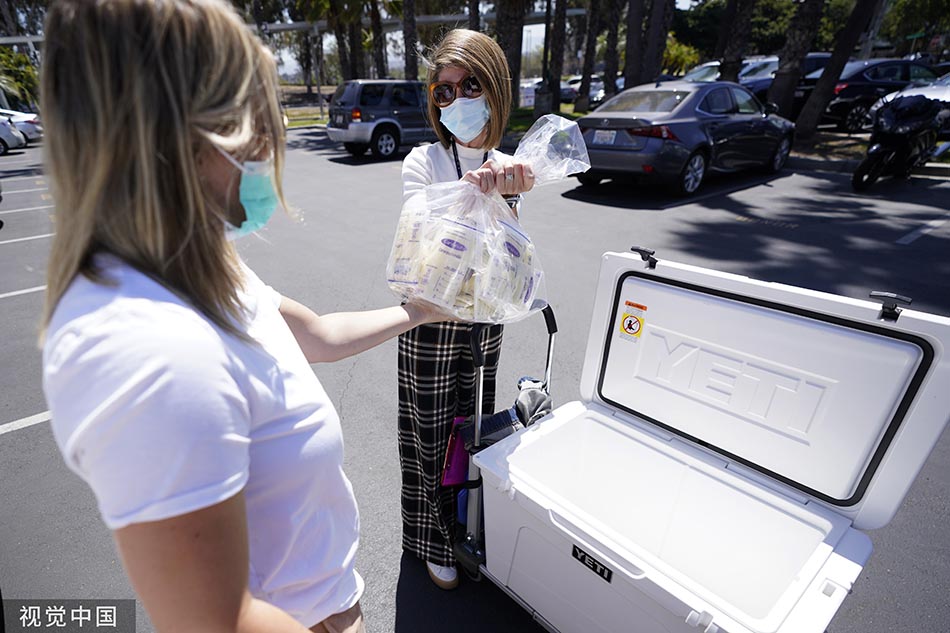 当地时间2022年5月13日，美国加州，一名妇女(左)向加州大学健康母乳银行的一名员工捐赠母乳。Gregory Bull/视觉中国