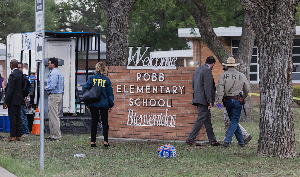 当地时间2022年5月24日，得克萨斯州尤瓦尔迪发生枪击事件后，执法部门在罗伯小学附近工作。