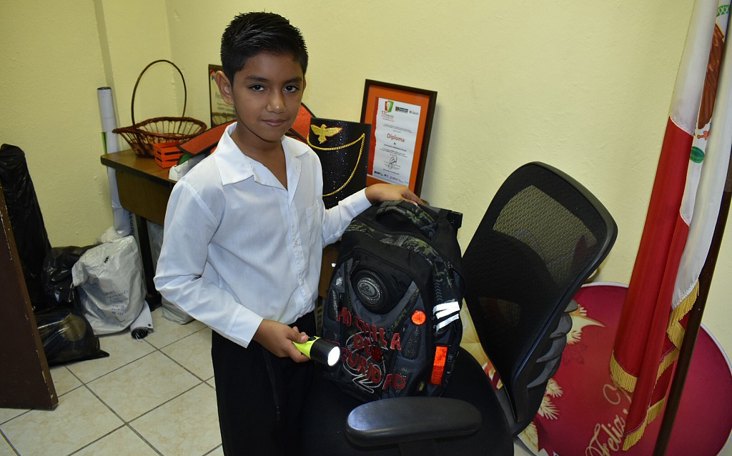 当地时间2016年11月25日，墨西哥，11岁的小男孩 Juan David Hernandez Rojas展示他发明的防弹背包。该包的背面刻有“安全背包”字样，重达五公斤（11 磅）。 它包括一个防弹钢板、一个紧急警报、一个 GPS 定位器、手电筒和一个手机充电器。