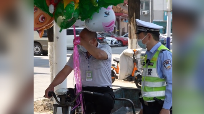 大爷牵气球骑车被交警拦下直抹泪，交警：我买俩气球给闺女