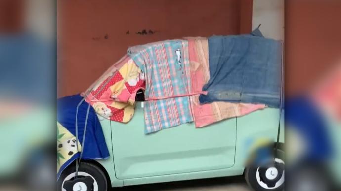 担心被弄脏，奶奶用床单包裹住孙女的新车