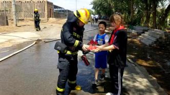 40℃高温天气，小朋友端来西瓜送处警消防员