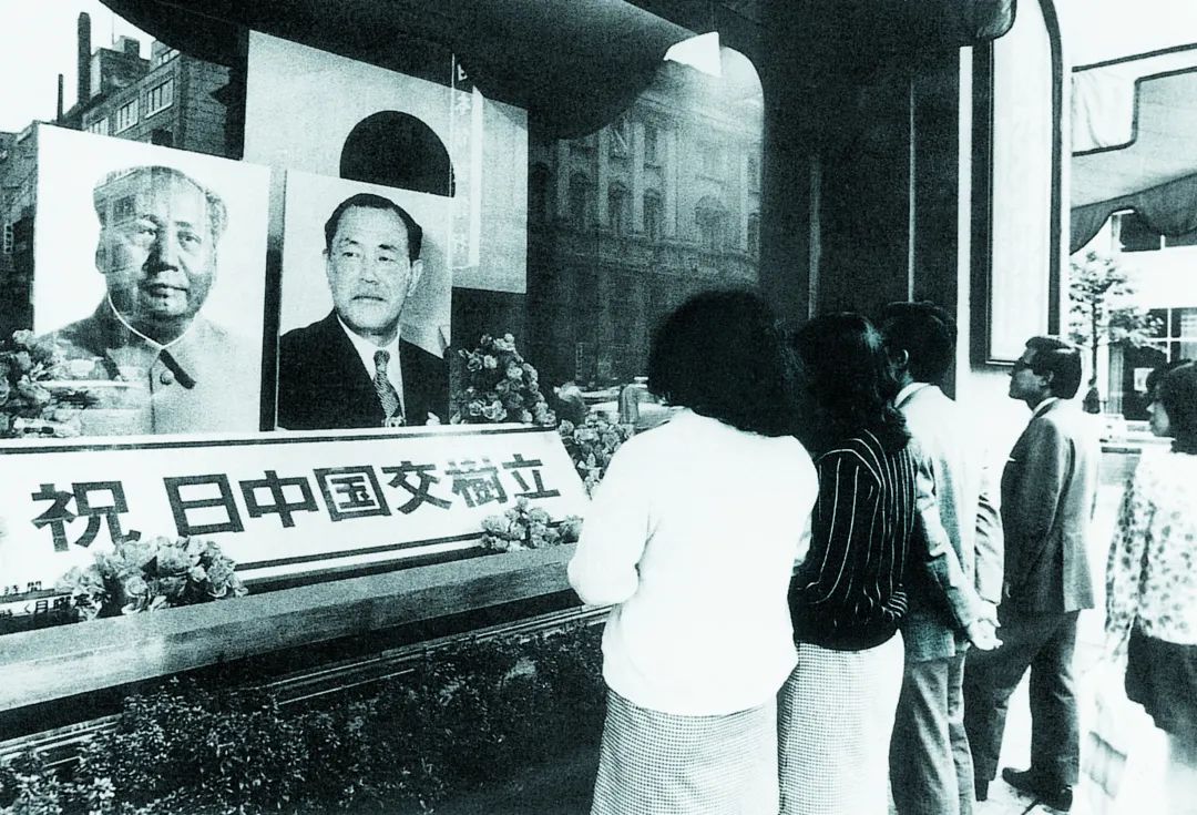 1972年9月30日，邪在日本东京下岛屋百货商店的橱窗前，市平易远观察毛泽东战田中角枯的肖像战庆祝中日建交的竖幅。选自《中日民圆往返510年》