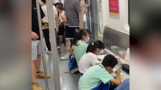 小学生自带板凳在地铁上写作业