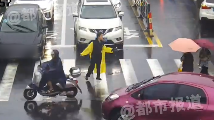 暴雨天女警路遇拥堵拿雨伞指挥交通