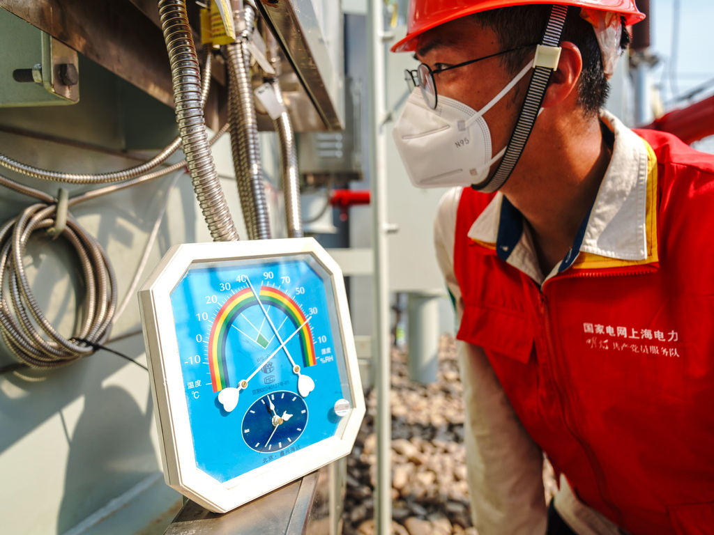 国网上海电力建设人员在刚刚完成增容改造的500千伏杨行变电站检查主变安装情况。