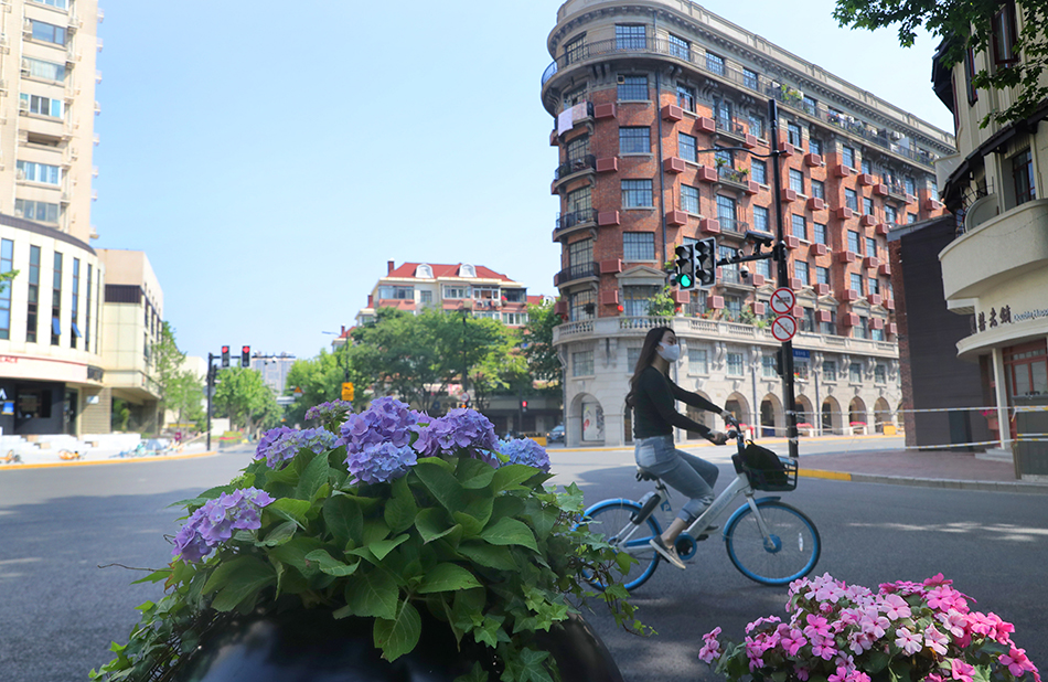 2022年5月17日，市民骑车从武康大楼前经过。 新华社记者 方喆 摄