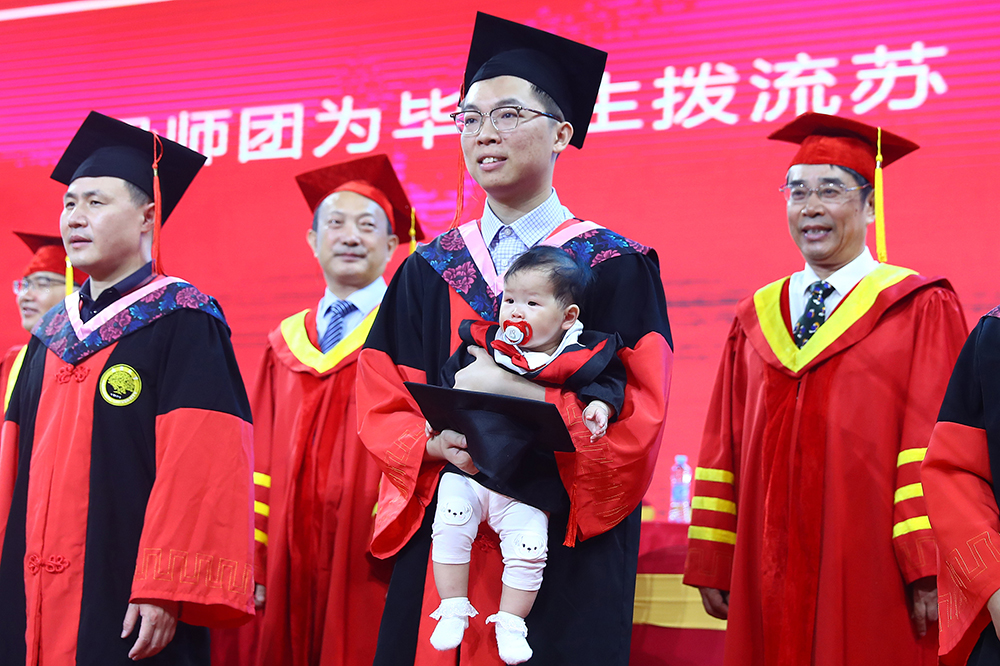 2022年6月20日，南昌大学一名博士毕业生携带自己8个月的孩子参加毕业典礼。中新社记者刘占昆/人民视觉 图