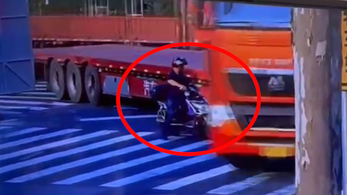骑车男子险被转弯大货车碾压，上海一辅警箭步冲入盲区内救人